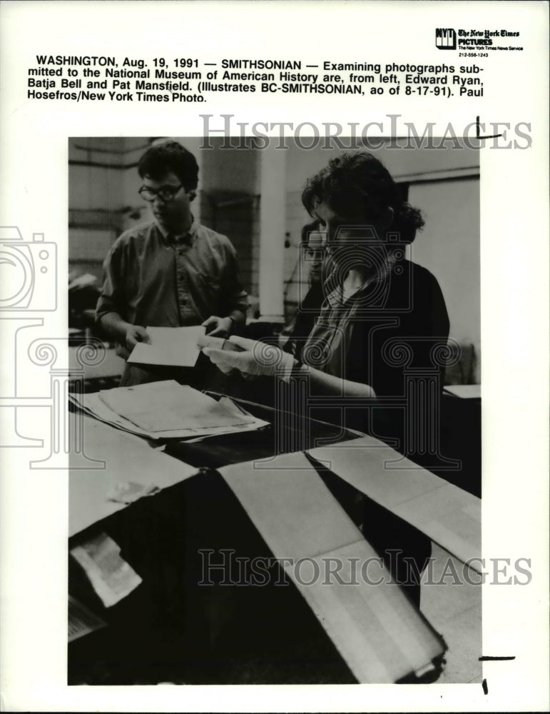 1991 Press Photo  Edward Ryan, Batja Bell and Pat  Mansfield examining photos- Historic Images