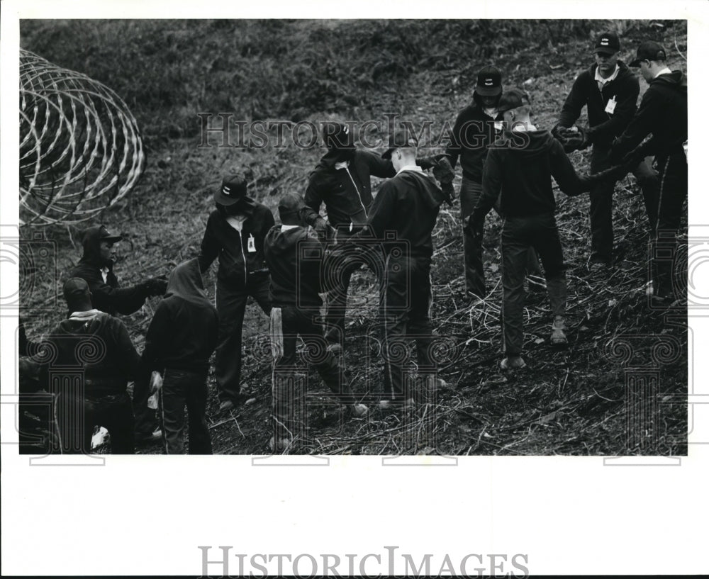 1991 Press Photo A work detail moves rocks up a hill outside of Camp Reams. - Historic Images