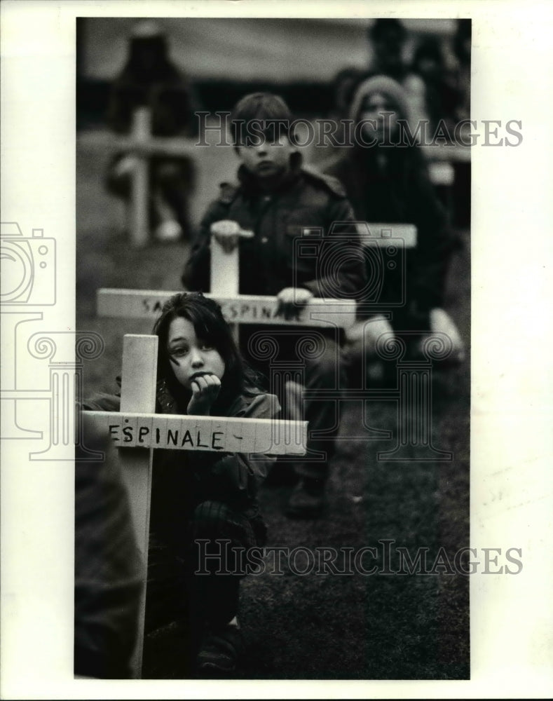 1986 Press Photo Eight year old Rachel Chorba of Cleveland holds a cross planted- Historic Images