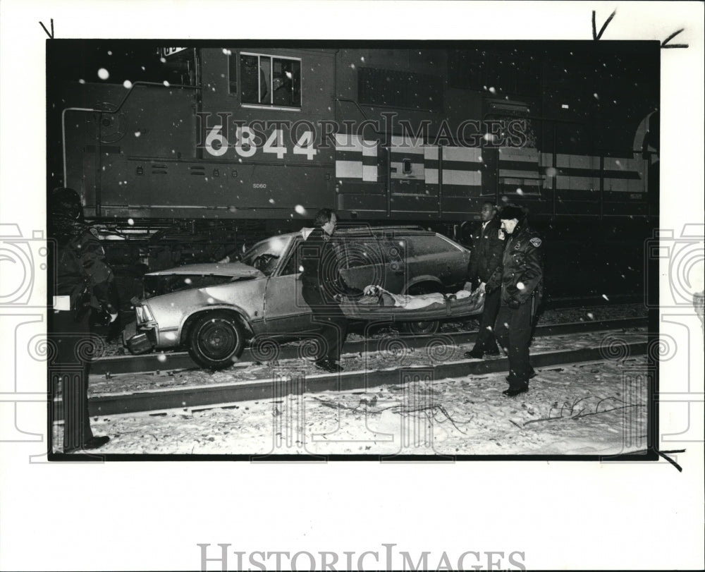 1990 Press Photo A policeman and an EMS technician carry one of the two survivor- Historic Images