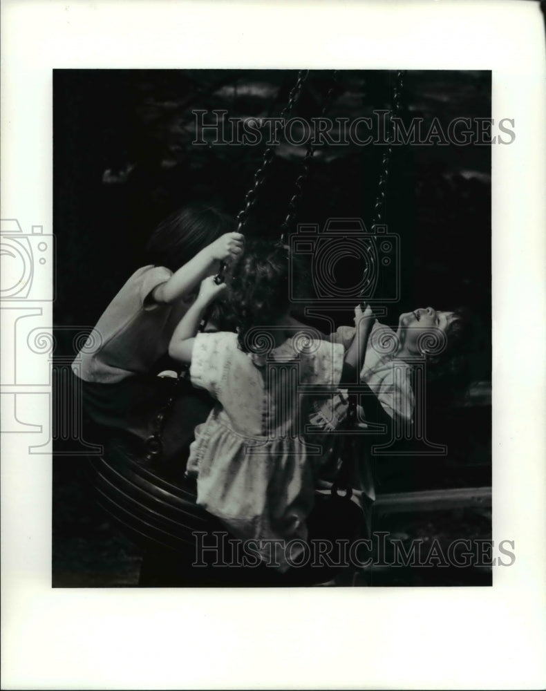 1990 Press Photo Chana Porter &amp; friend on the tire swing at Cain Park.- Historic Images