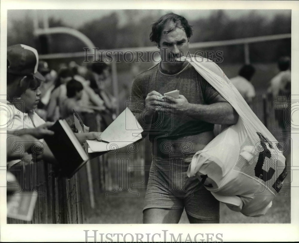 1984 Press Photo Doug Dieken Carries Pads in his Teeth While Signing Autograph- Historic Images