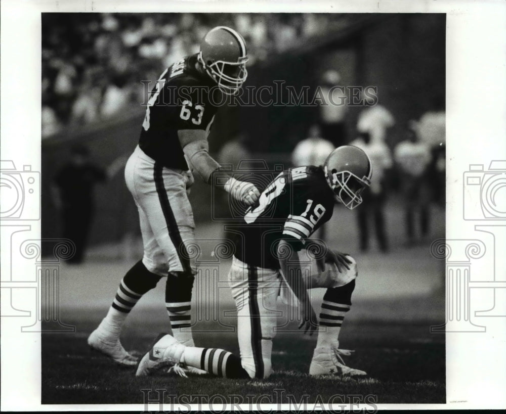 1989 Press Photo Cody Risieb helps Bernie in a football field action - cvb40596- Historic Images