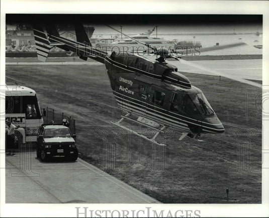 1990 Press Photo Al Unser Jr. & a crew members being air lifted after pit fire- Historic Images