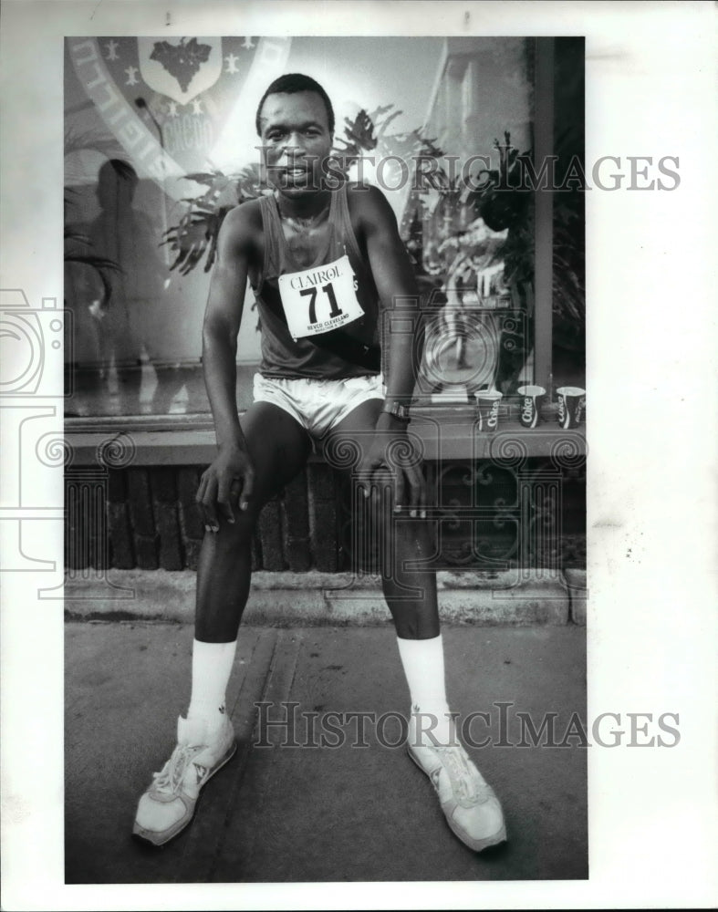 1989 Press Photo 10K Winner Yobes Ondieki Rest on a Store Frontledge - cvb49288- Historic Images