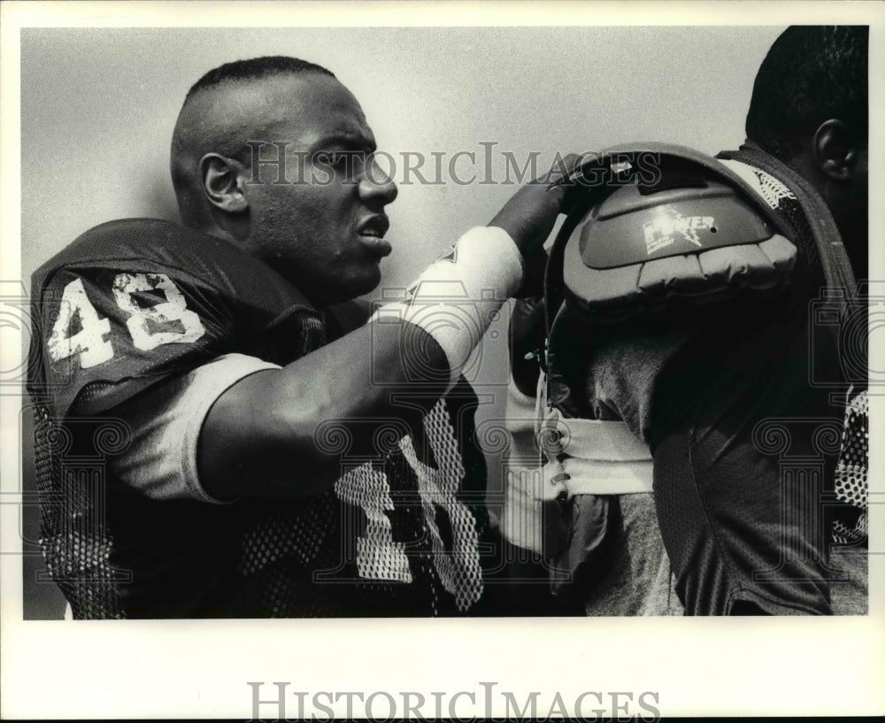 1988 Press Photo Brian Washington assists Van Waiter with his shoulder pads- Historic Images