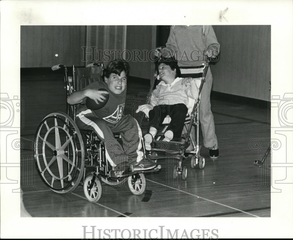 Press Photo Eleven year old Brad Zidek with football in wheelchair - cvb50682- Historic Images