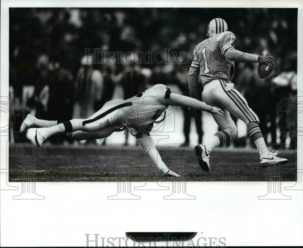 1988 Press Photo David Grayson lunges to Oilers Qarren Moon in football game.- Historic Images