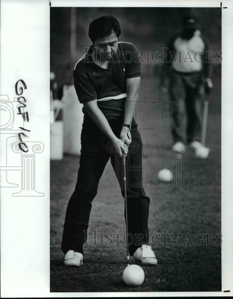 1990 Press Photo Hong Lee is teeing off a softball instead of a golf ball- Historic Images