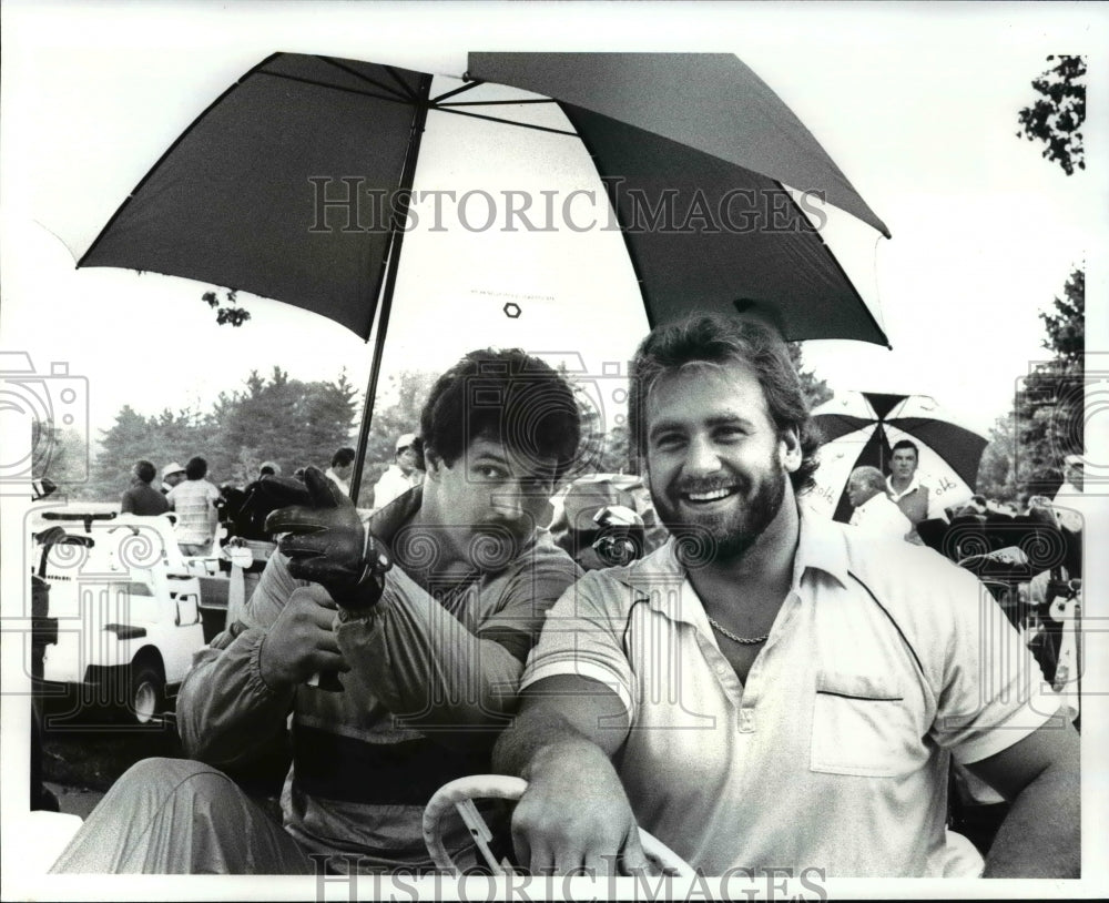 1986 Press Photo Dan Fike and Bob Golic leaving in a golf cart at Kirtland CC.- Historic Images