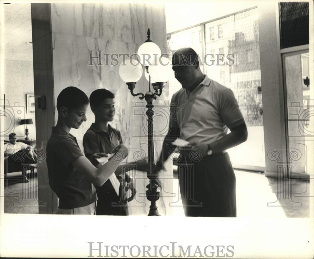 Press Photo Two boys happily greet a gentleman in a building - ftx03812- Historic Images