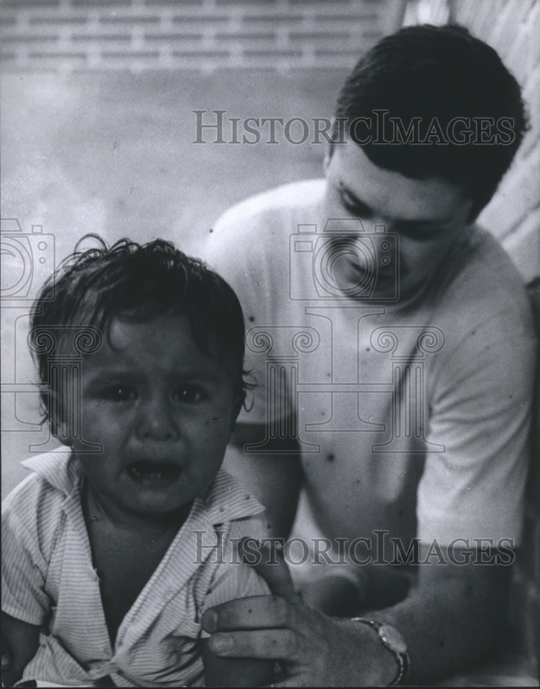 1968 Press Photo Fred Lybrand, Operation Amigo, of Houston helps give baby shot