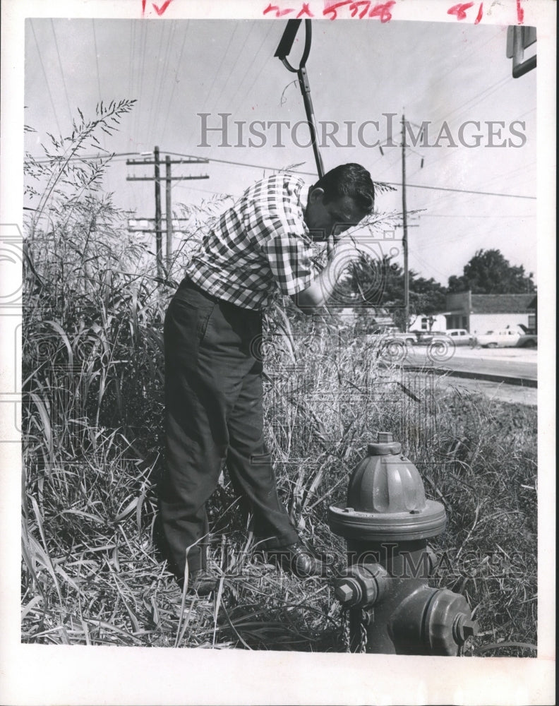 1966 Press Photo C.M.Pumphrey Jr. Cuts Grass Around Fireplug in Boling Texas- Historic Images