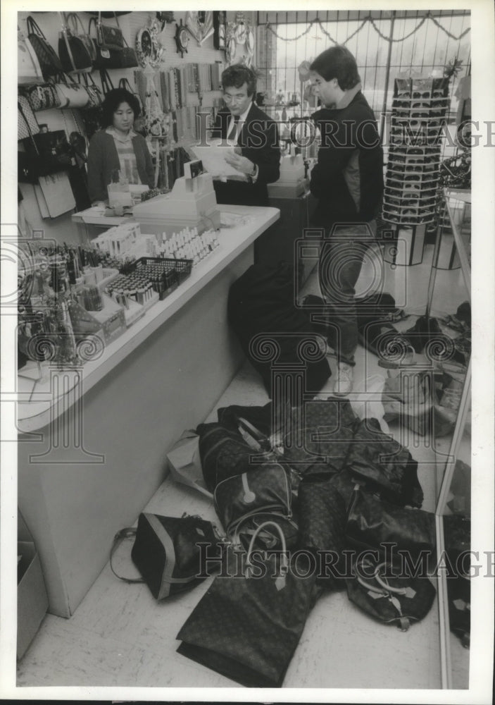 1986 Press Photo Kyung Kim &amp; U.S. Marshals Confiscate Counterfeit Goods.- Historic Images