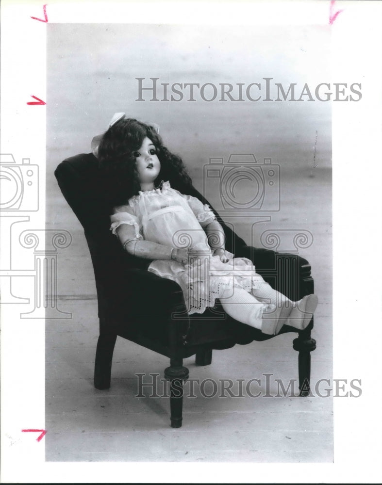 1991 Press Photo Porcelain Doll in Chair Attends Small World Ventures Toy Show.- Historic Images