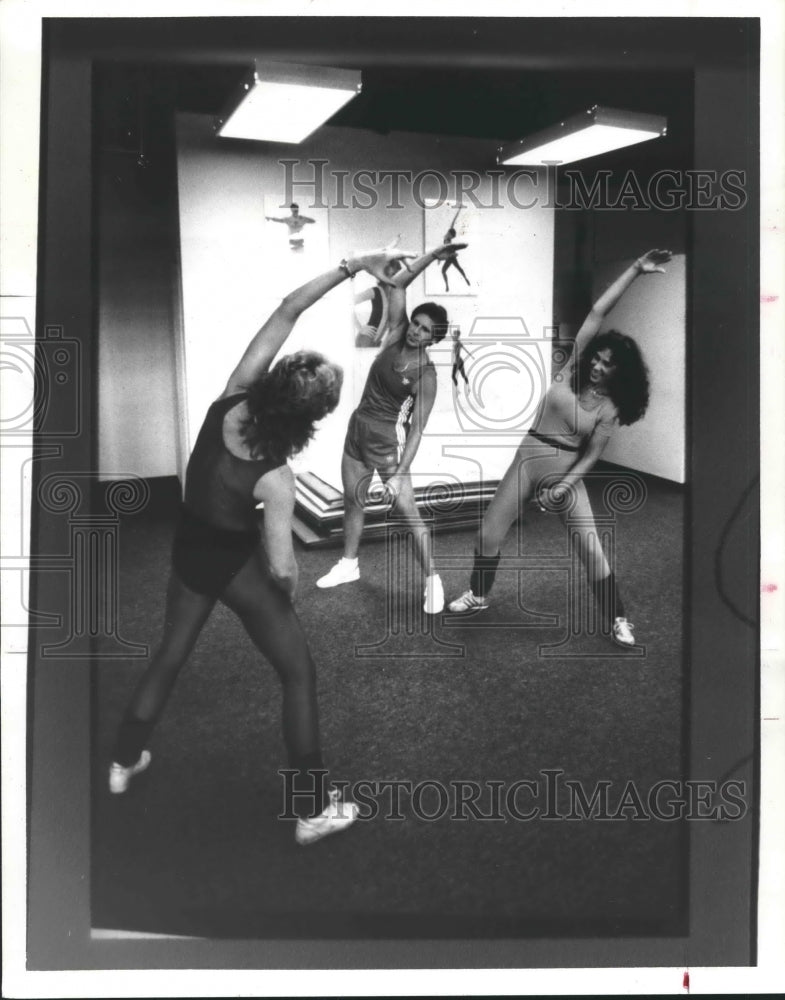 1984 Press Photo Three people stretch and exercise - hca24124- Historic Images