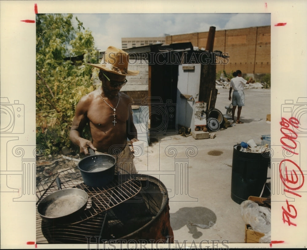 1992 Press Photo Homeless vet Clinton Allen cooks in shanty town in Houston