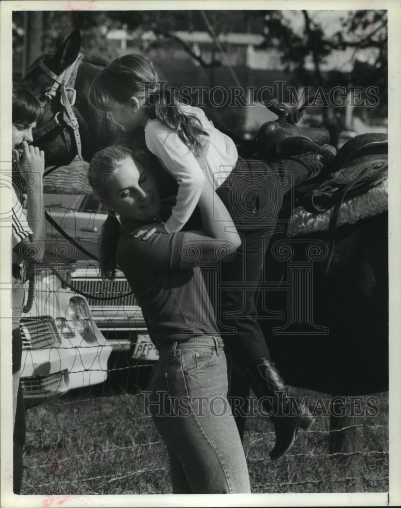 1983 Press Photo Volunteer helps child off horse in Texas - hca30806- Historic Images