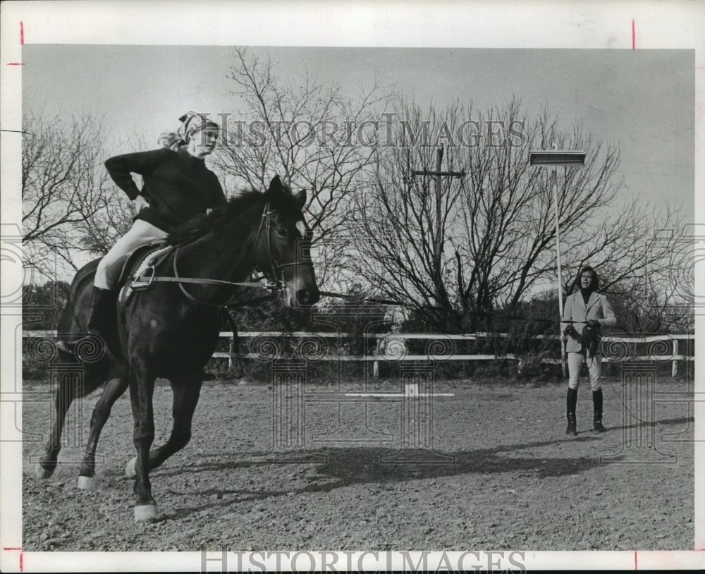 1977 Press Photo Woman exercises on horse while a trainer watches - hca31388- Historic Images