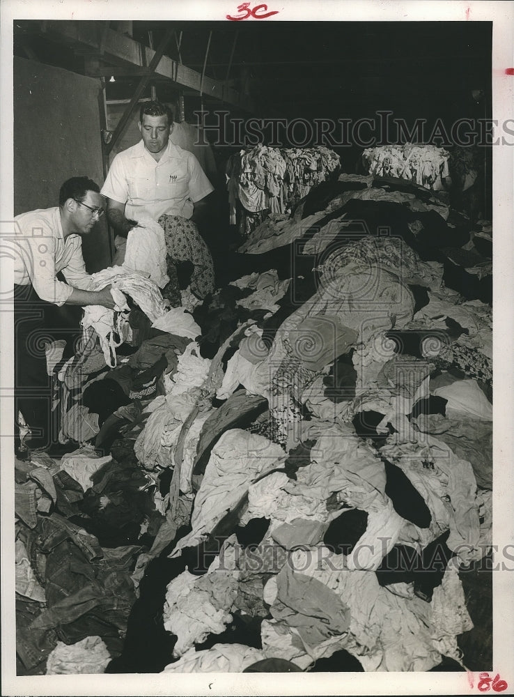 1956 Press Photo Men sort through material pile at Houston Wiper & Mill Supply