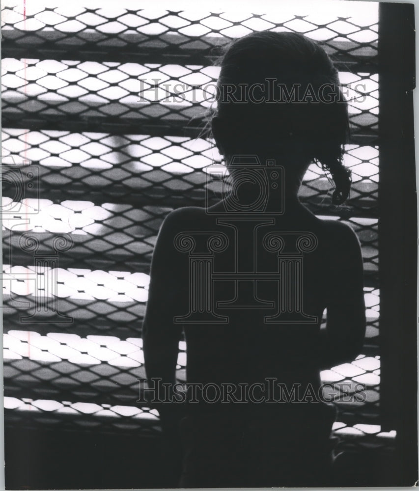 1962 Press Photo Silhouette of young girl looking through fence in Harris Co TX- Historic Images