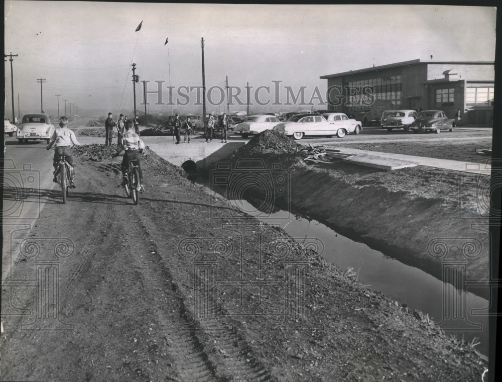 1950 Press Photo Students ride bike by Will Rogers Elementary School - hca33961