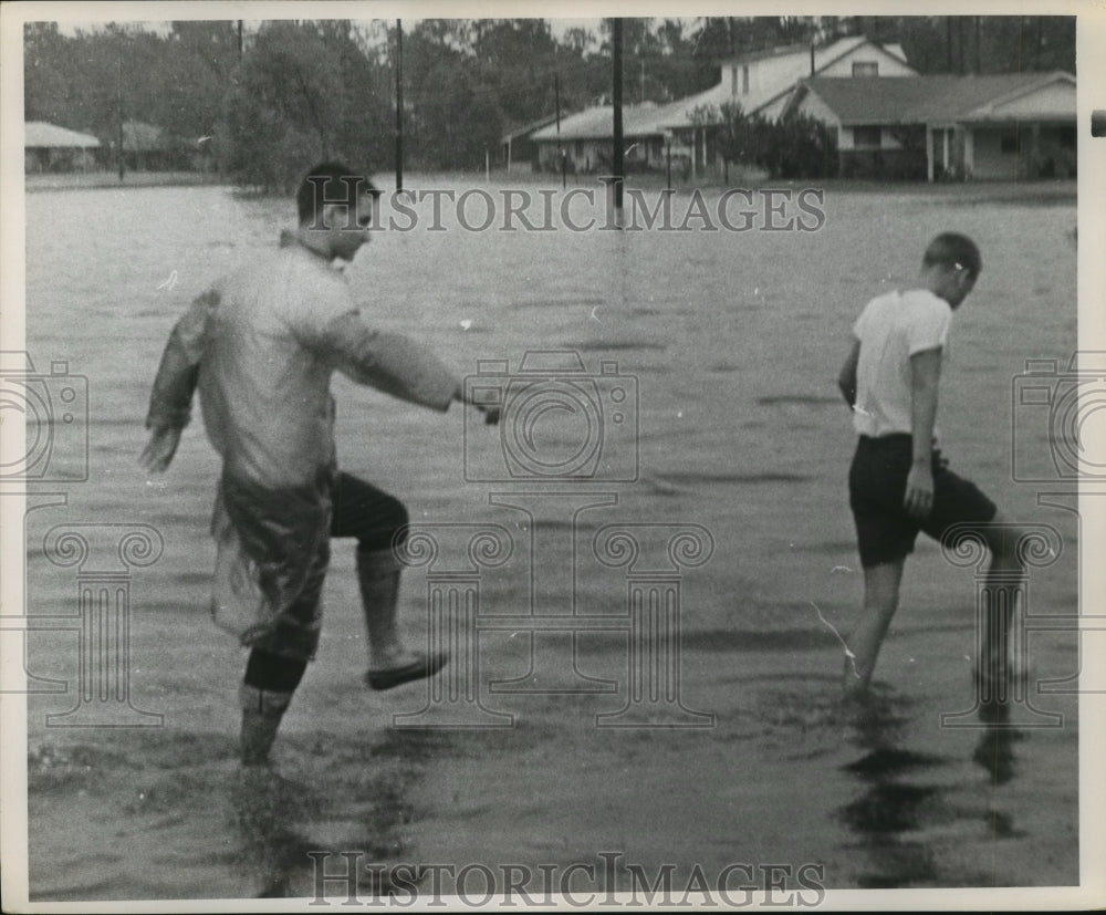 1961 Press Photo Boys hike through flooded Houston street after Hurricane Carla