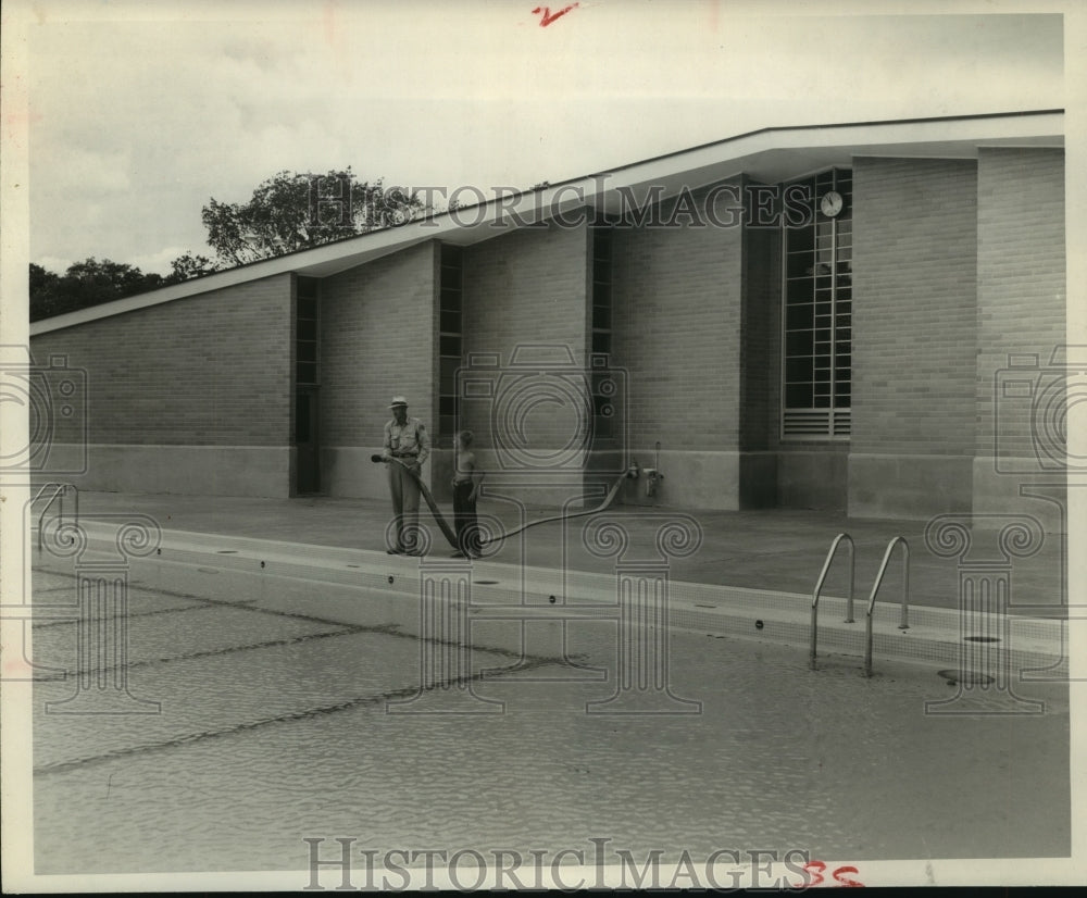 1954 Press Photo Man holds hose near MacGregor Park swimming pool - hca37510