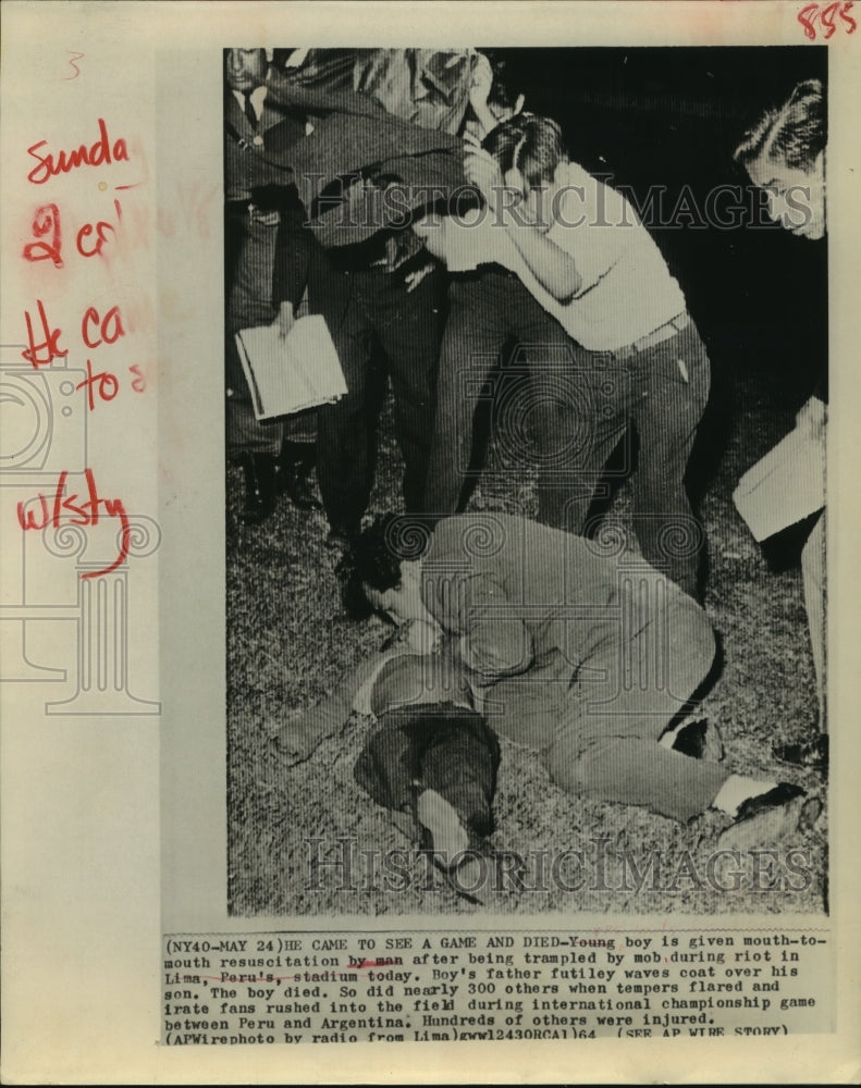 1964 Press Photo Boy given CPR after being trampled at soccer riot in Lima, Peru