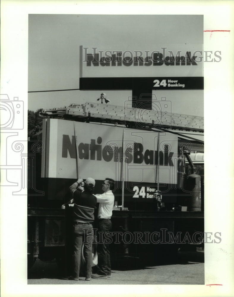 1992 Press Photo Workers put up NationsBank sign in TX; NCNB/C&amp;S-Sovran merger- Historic Images