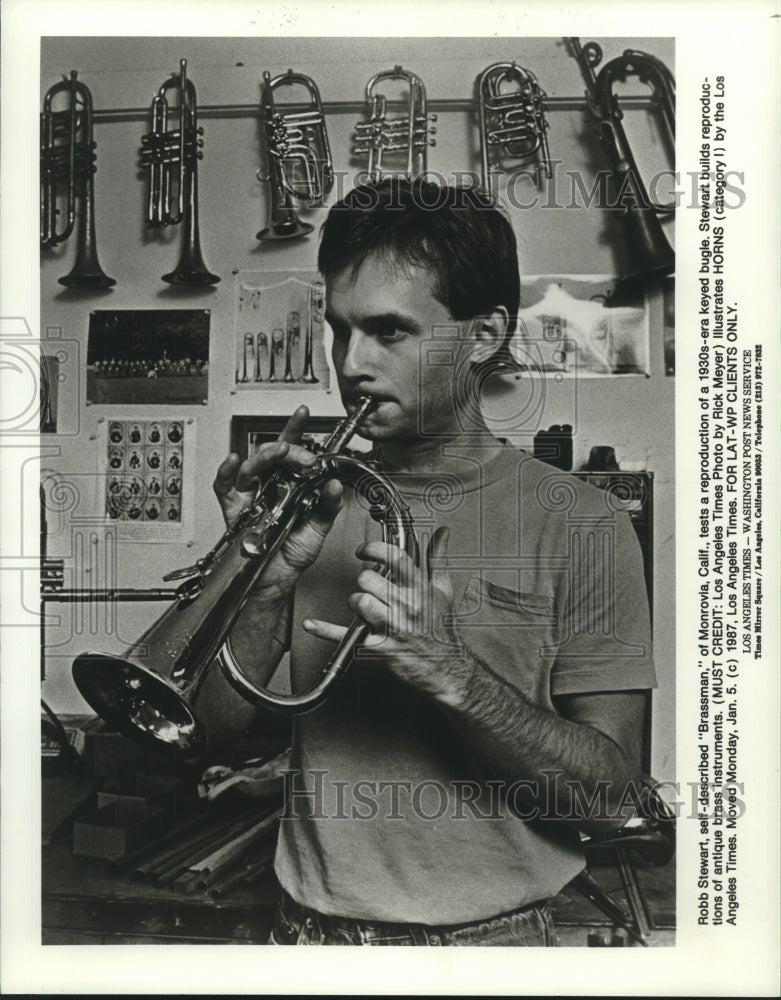 1987 Press Photo Robb Stewart tests a 1930s-era keyed bugle he reproduced in CA- Historic Images