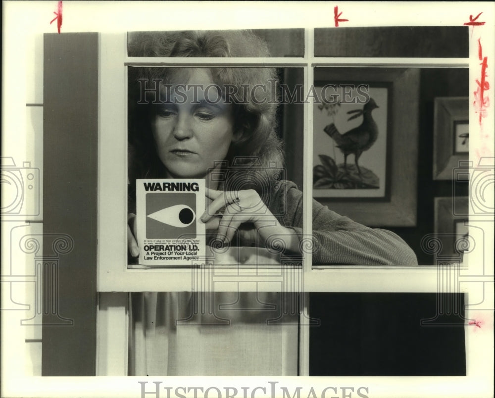 1977 Press Photo Sarah Morris places Operation I.D. sticker in her home window