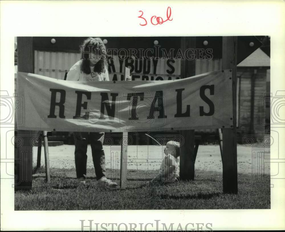 1989 Press Photo Lisa Gregory With Daughter Kayla Setting Up Video Rental Sign- Historic Images