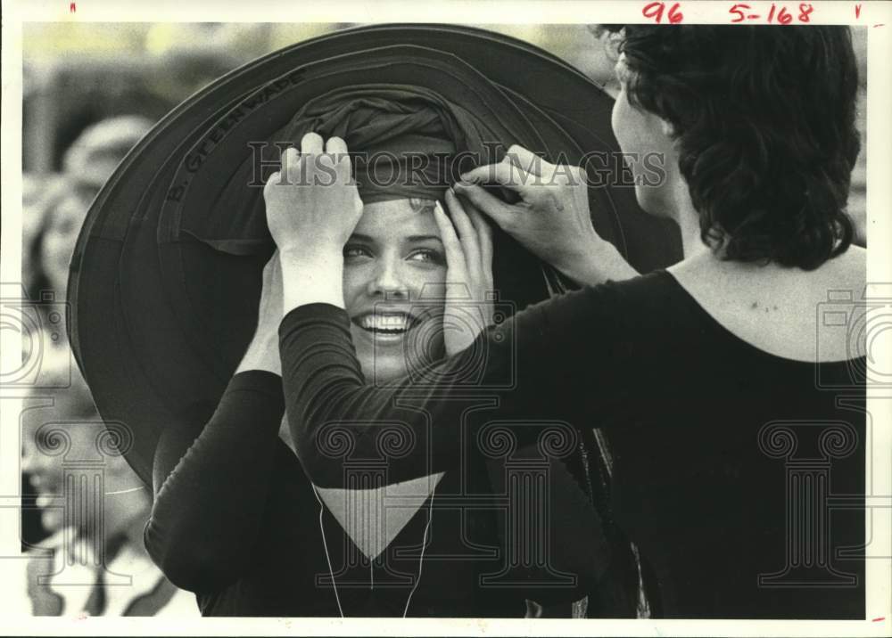 1984 Press Photo Brigette Greenwade puts on hat, Markett, Spring Branch, Texas- Historic Images