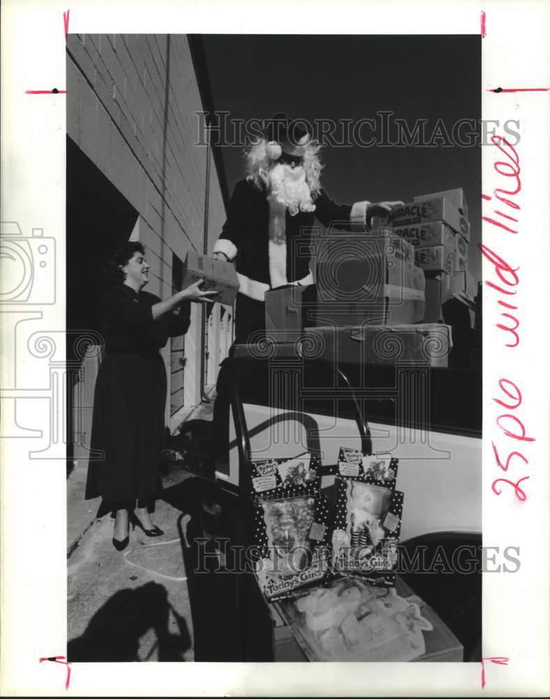 1990 Press Photo Sandra Howard Helps Santa Load Toys in Houston, Texas- Historic Images