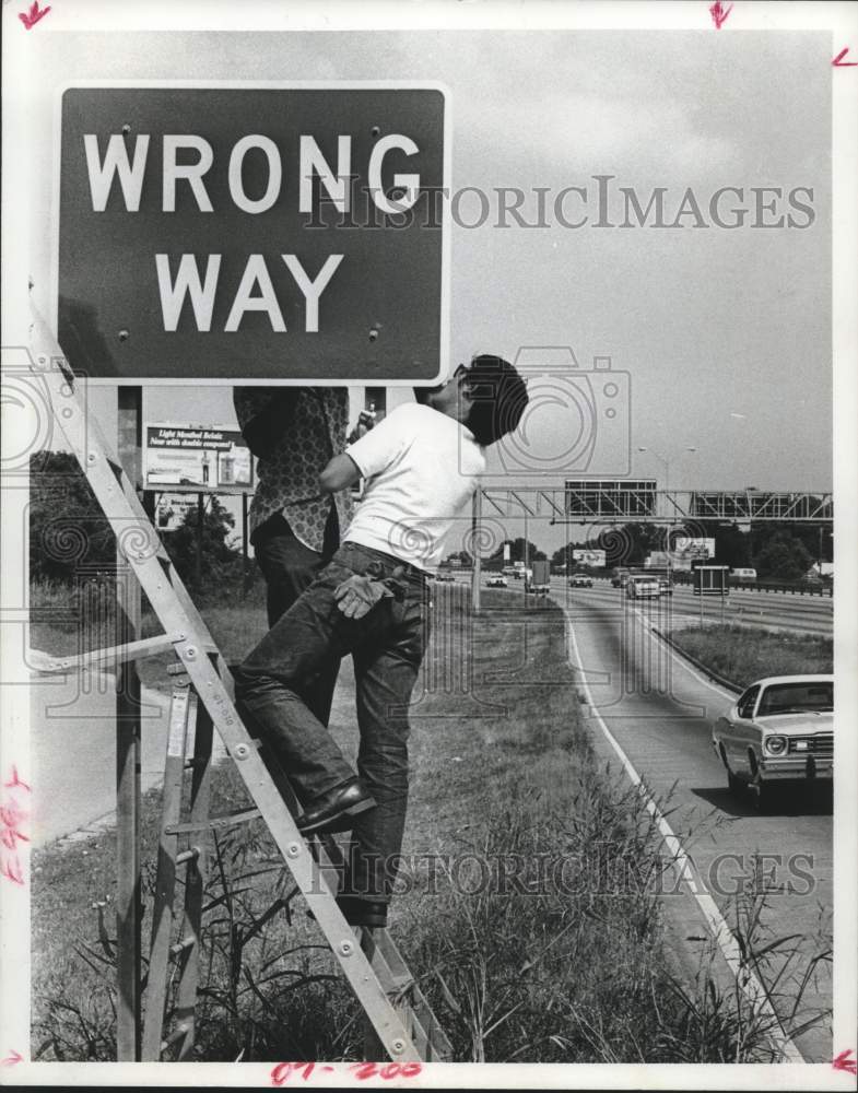 1977 Press Photo Jonathan Kin Helps Install Sign on Katy Freeway, Houston, Texas- Historic Images