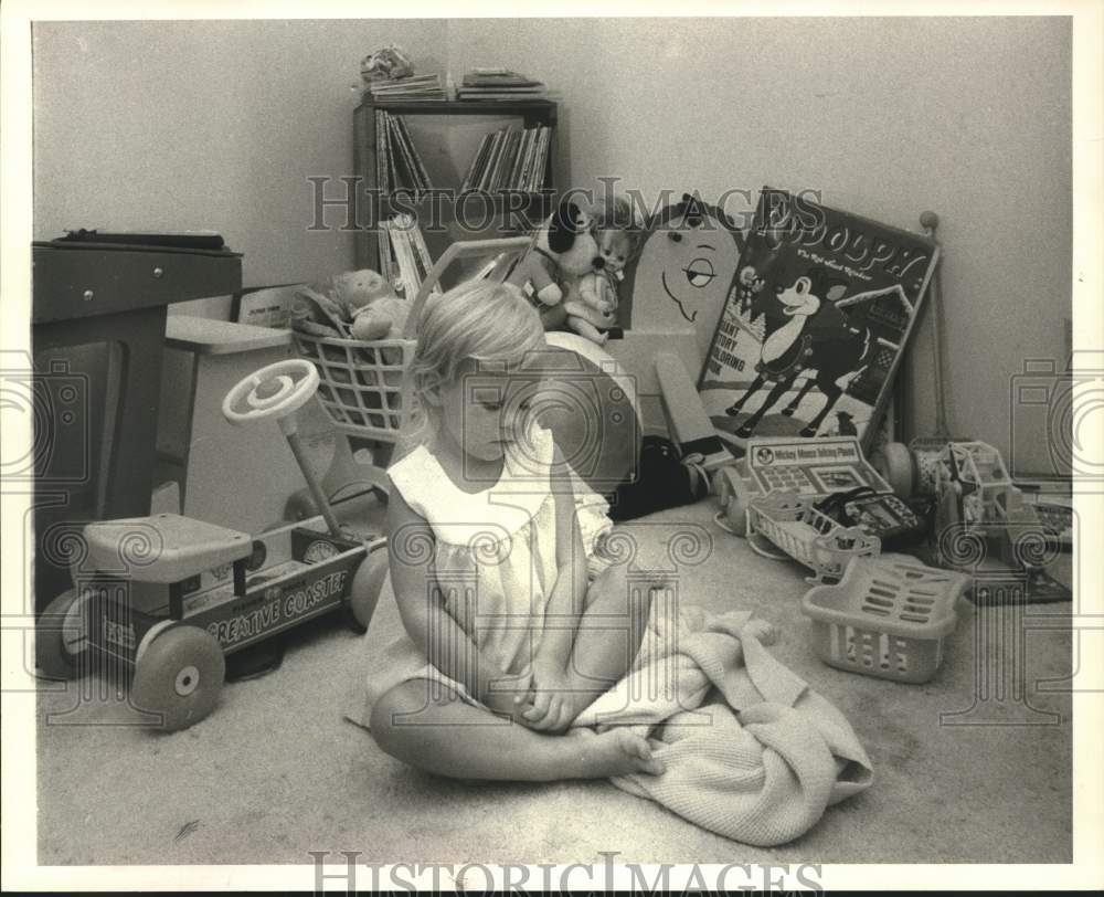 1980 Press Photo Laura Scherler, bored child in a room full with toys- Historic Images