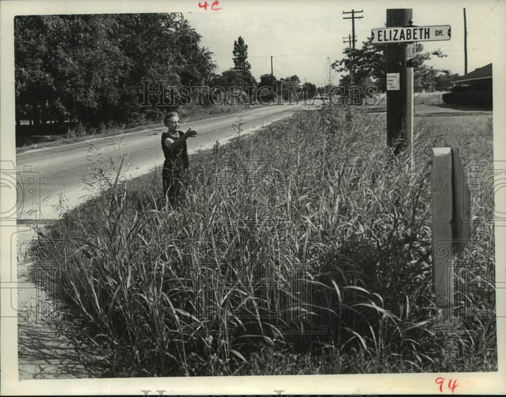 1965 Press Photo Nelda Krause points out overgrown weeds on city land in Houston- Historic Images