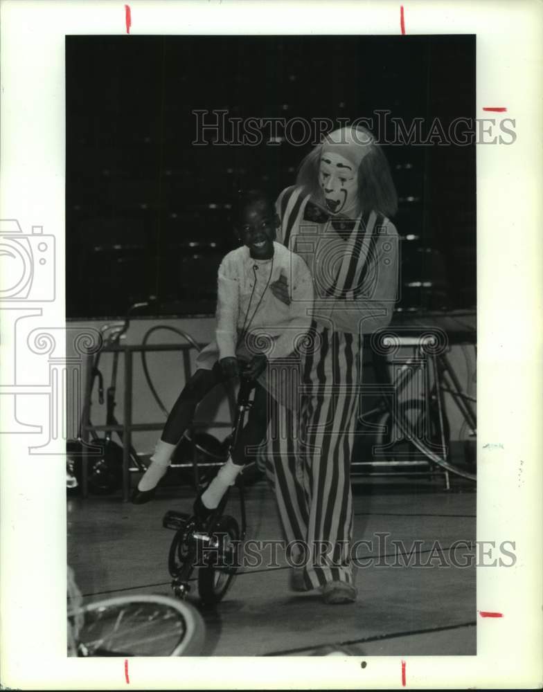 1990 Press Photo Klandra Geter gets unicycle help from clown, Houston United Way- Historic Images