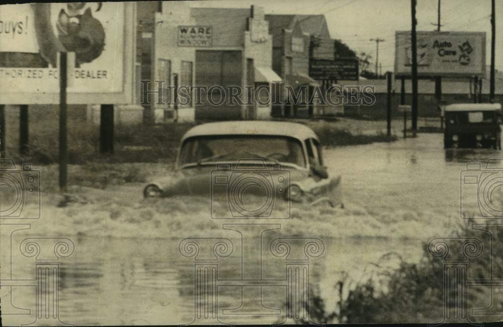 1958 Press Photo With flood-water up to headlights, car keeps on going; Houston