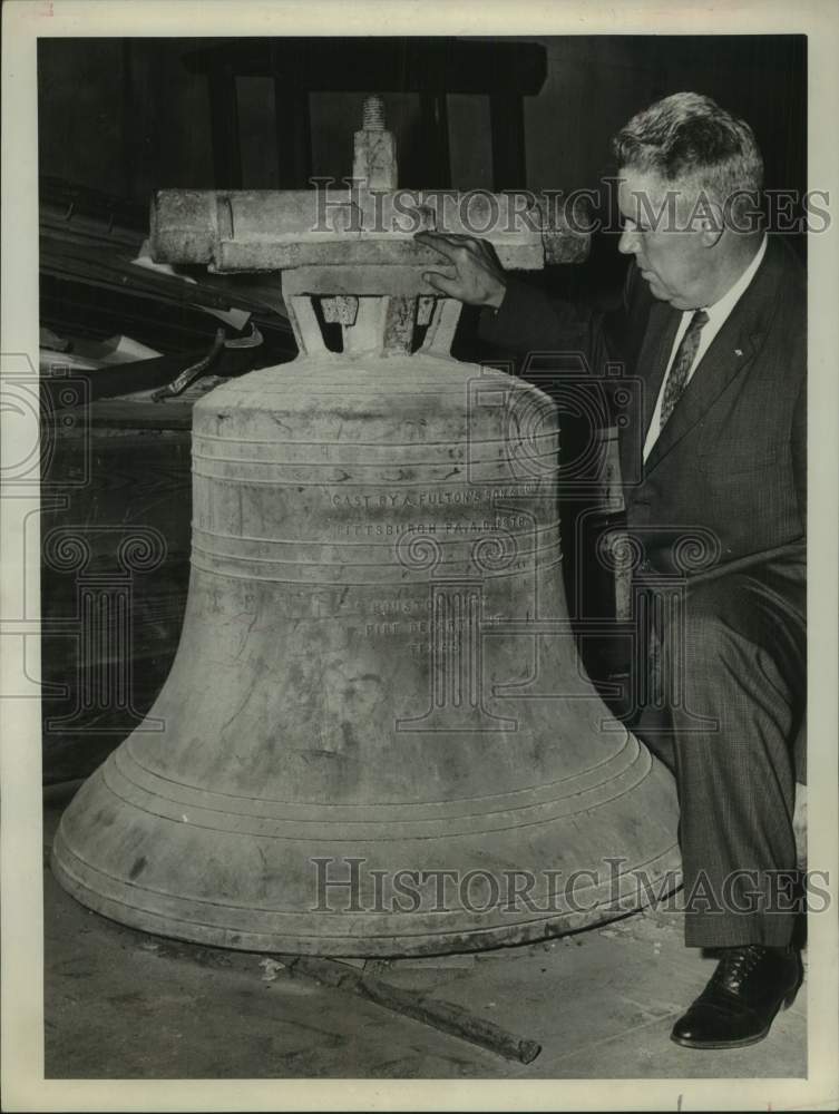 1960 Press Photo File Chief Claude M. Bullock examines bell - hca75438