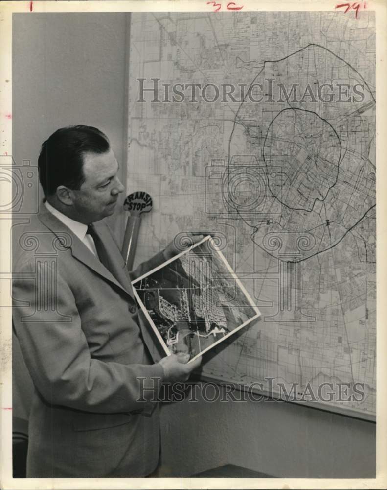 1961 Press Photo Bernard Calkins examines photos, map of Houston transportation- Historic Images