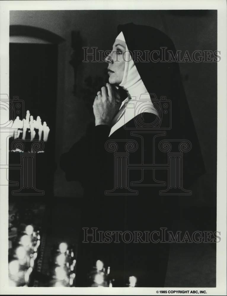 1985 Press Photo Nun kneels and prays - Joan Collins movie scene - hca81176- Historic Images