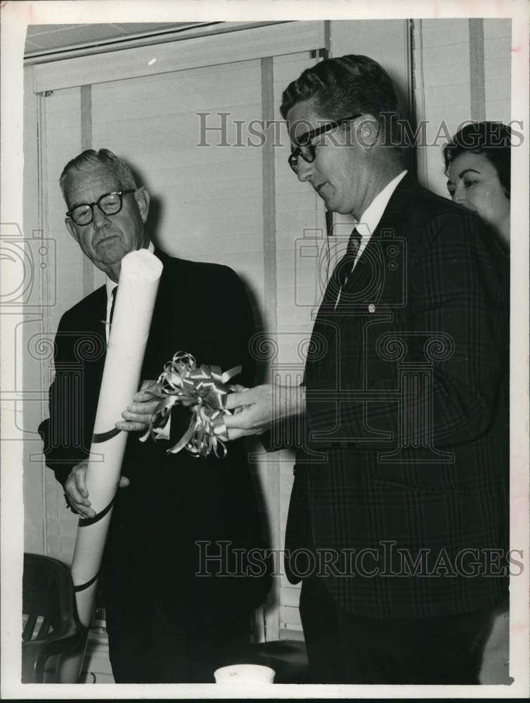 1966 Press Photo J. L. DuRoss unwraps new rod as Charles Ament looks on- Historic Images