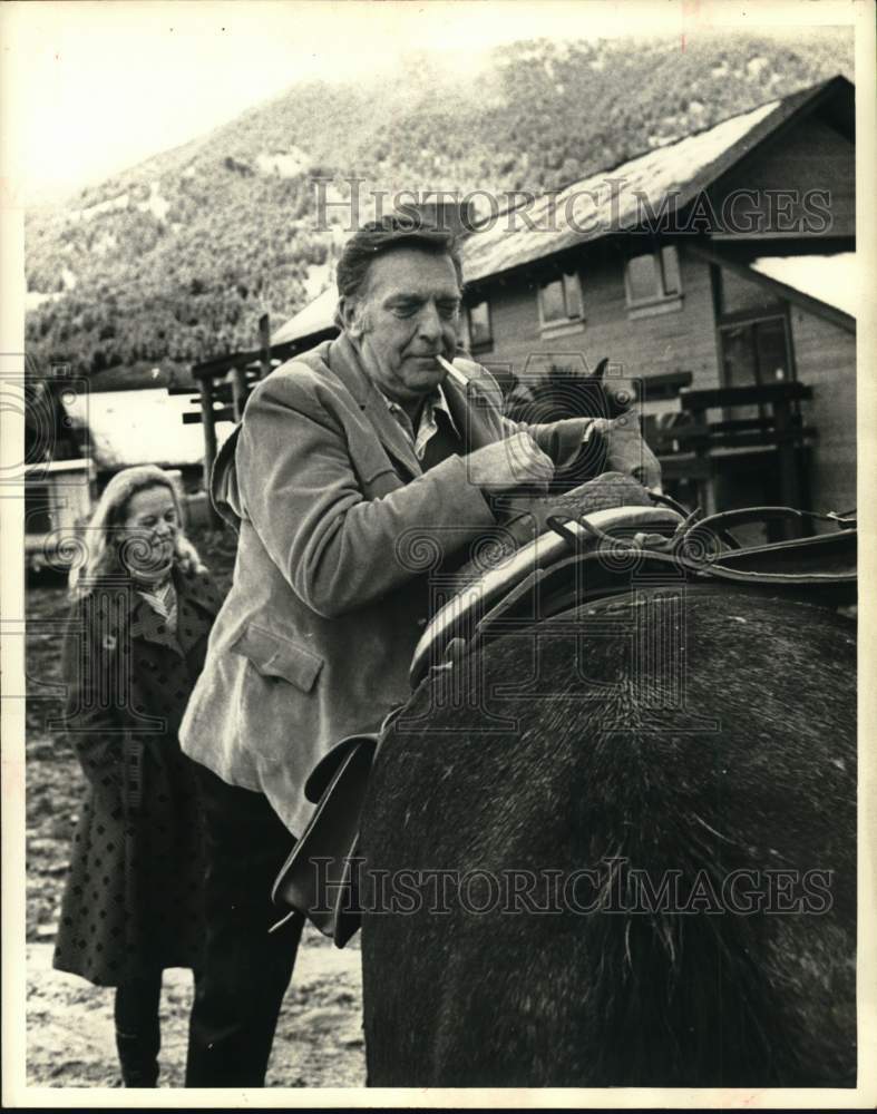 1971 Press Photo Chet Huntley mounting his horse at the Big Sky resort- Historic Images