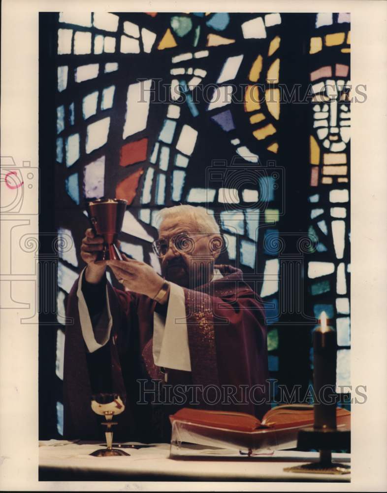 1989 Press Photo Reverend William Schumacher holds chalice at St. Patrick Church- Historic Images