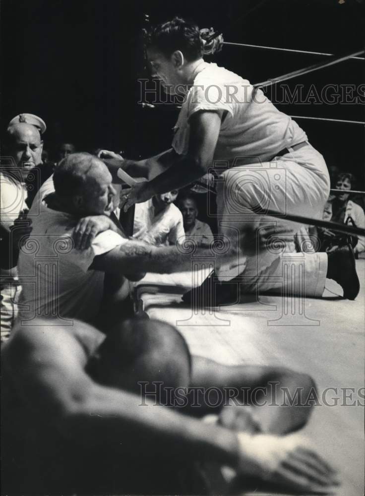 1965 Press Photo Wrestler Wells Twombly is pushed back from ring by spectators.- Historic Images