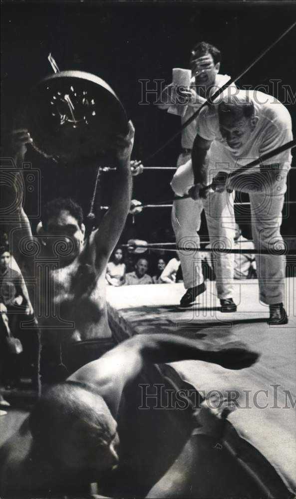 1965 Press Photo Wrestler Wells Twombly holds the bell up that starts the match.- Historic Images