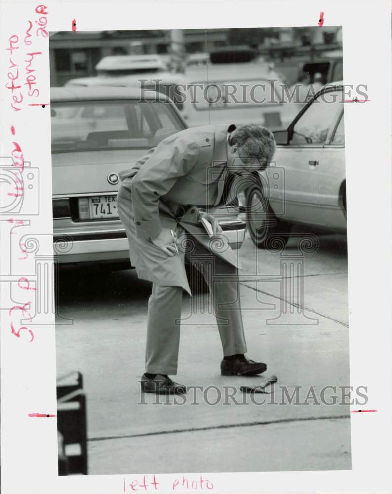 1991 Press Photo Houston police officer John Silva examines hatchet.- Historic Images