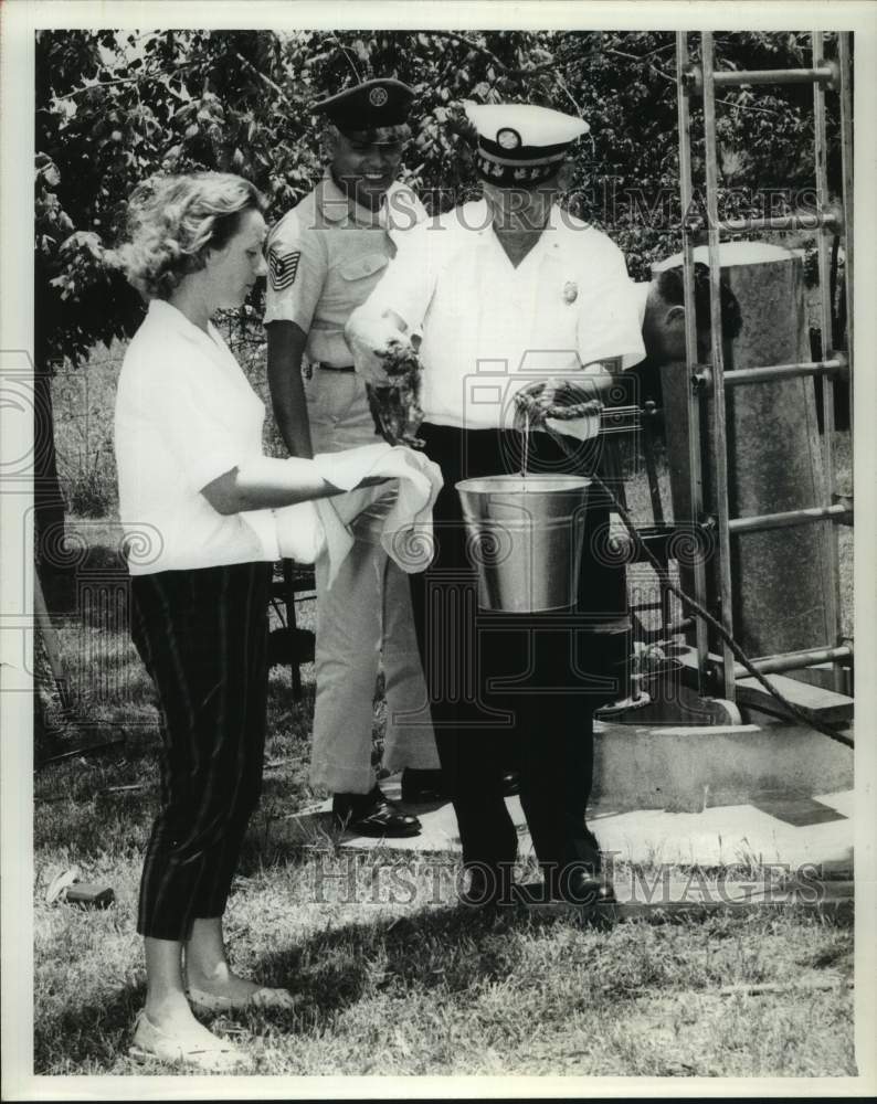 1963 Press Photo Bergstrom AFB firemen rescue kitten from well - Texas
